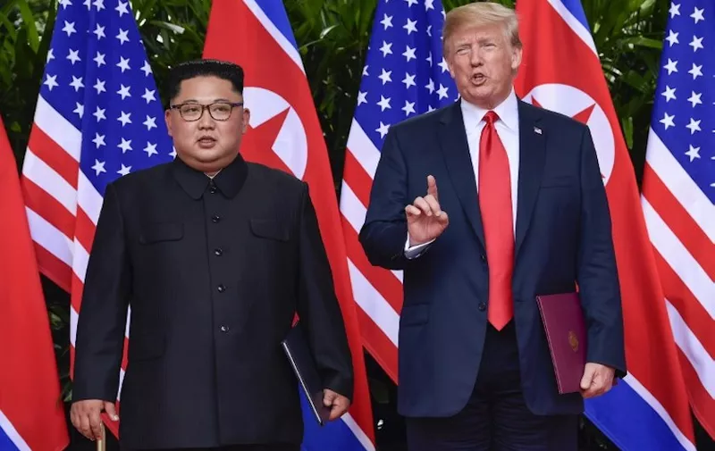 US President Donald Trump makes a statement before saying goodbye to North Korea leader Kim Jong Un (L) after their meetings at the Capella resort on Sentosa Island in Singapore on June 12, 2018. 
Donald Trump and Kim Jong Un became on June 12, the first sitting US and North Korean leaders to meet, shake hands and negotiate to end a decades-old nuclear stand-off. / AFP PHOTO / POOL / Susan Walsh