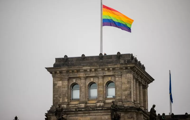 23 July 2022, Berlin: The rainbow flag is hoisted on the southwest tower of the Reichstag building on the occasion of Berlin's Christopher Street Day (CSD). This year's motto of the parade for the rights of lesbian, gay, bisexual, transgender, intersex and queer people is "United in Love! Against Hate, War and Discrimination." Photo: Christoph Soeder/dpa (Photo by Christoph Soeder / DPA / dpa Picture-Alliance via AFP)