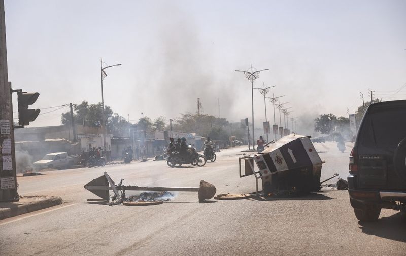 Burning barricades are seen in the central avenues in Ouagadougou where group of young demonstrators supporting the role of the army protested against President Marc Christian Kabore on January 23, 2022. - Soldiers mutinied on Sunday in several barracks in Burkina Faso to demand the departure of army chiefs and "more suitable means" to fight against the jihadists who have struck this country since 2015. (Photo by OLYMPIA DE MAISMONT / AFP)