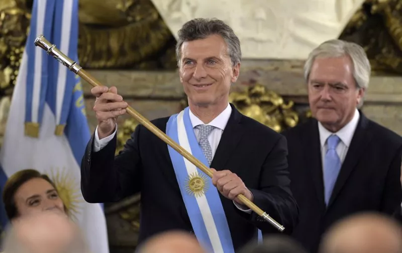 Argentine President Mauricio Macri, already wearing the presidential sash and staff, during his inauguration at the Casa Rosada government palace in Buenos Aires on December 10, 2015. Macri's inauguration marks the start of a new era for Argentina: a tilt to the right after 12 years under Kirchner and her late husband Nestor, the left-wing power couple that led the country back to stability after an economic meltdown in 2001.   AFP PHOTO/JUAN MABROMATA / AFP / JUAN MABROMATA