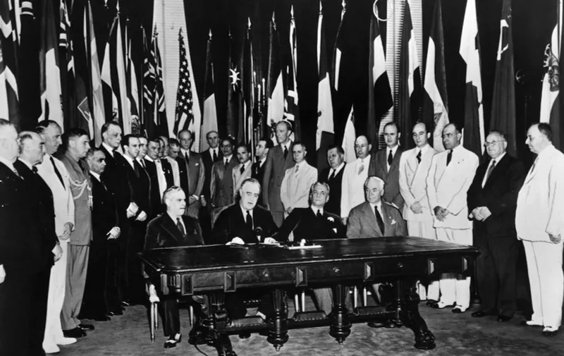 US President Franklin D. Roosevelt (2nd L) reads a statement among representatives of United Nations members during their formal pledge to cooperate for victory and to adhere to the Atlantic Charter in Washington D.C. 01 January 1942.  AFP PHOTO (Photo by HO / UNITED NATIONS / AFP)