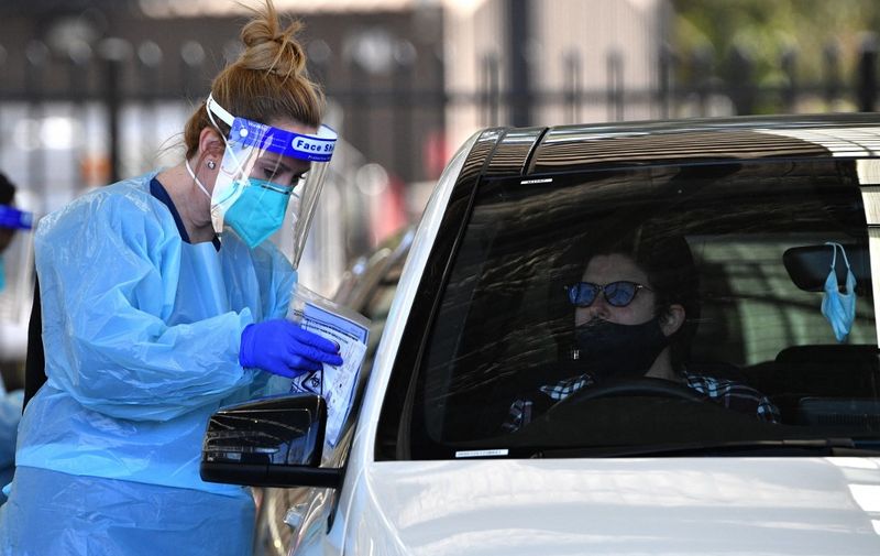 A health worker takes a swab sample from a resident at a Covid-19 drive-through testing clinic in Sydney on July 28, 2021. (Photo by Saeed KHAN / AFP)