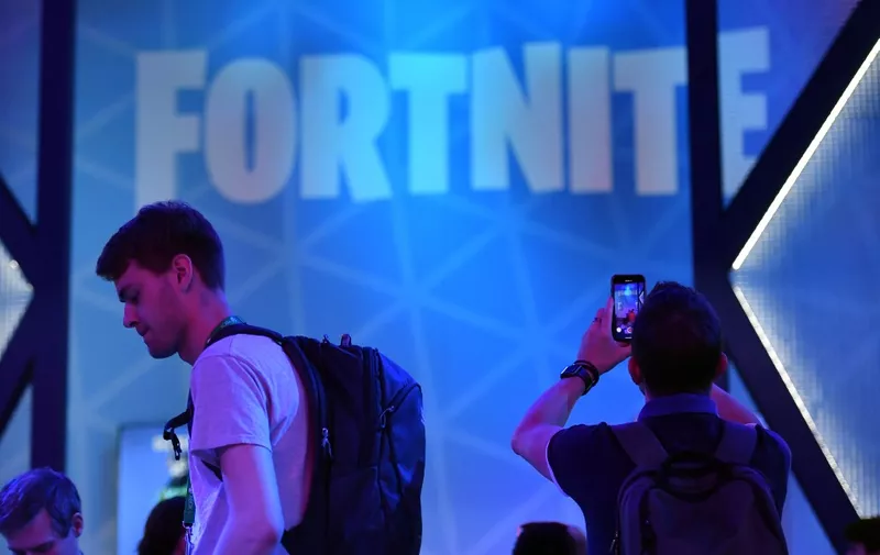 A visitor takes pictures at the stand of the "Fortnite" computer game at the media day of the Gamescom video games trade fair in Cologne, western Germany, on August 20, 2019. (Photo by Ina FASSBENDER / AFP)