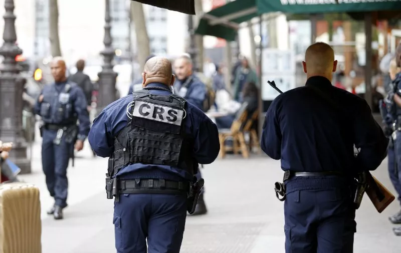 French CRS police officers patrol outside the Gare du Nord train station in Paris on April 22, 2017, after a man carrying a knife was arrested.
The arrest on April 22 at Paris's Gare du Nord caused brief panic days after the jihadist killing of a policeman, police sources said amid pre-election jitters. "An individual carrying a knife came into the station, was pointed out to a police patrol which immediately arrested him," one of the sources said. The incident came two days after the Champs Elysees killing of a policeman and one day before France goes to the polls in the first round of close-run presidential elections.
 / AFP PHOTO / GEOFFROY VAN DER HASSELT