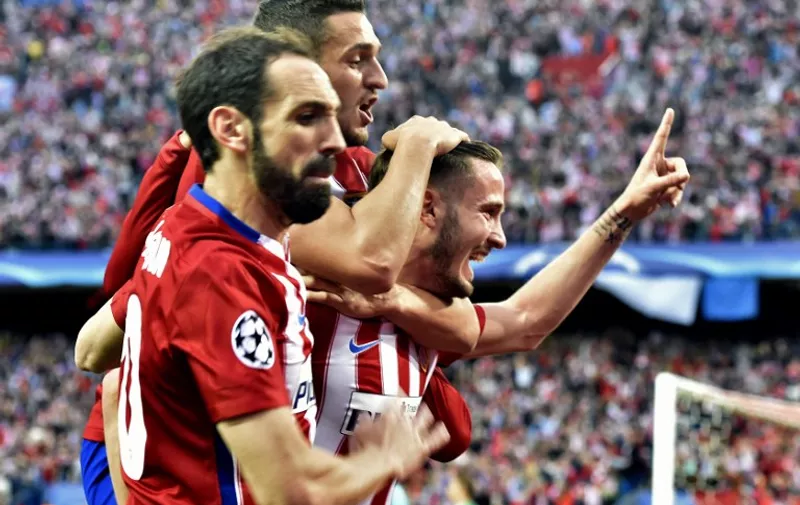 Atletico Madrid's midfielder Saul Niguez (R) celebrates with teammates  during the UEFA Champions League semifinal first leg football match Club Atletico de Madrid vs Bayern Munich at the Vicente Calderon stadium in Madrid on April 27, 2016. / AFP PHOTO / GERARD JULIEN