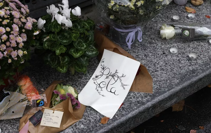A photograph shows flowers displayed outside the middle school Georges Brassens in Paris on October 17, 2022, where studied a 12-year-old schoolgirl, named Lola, three days after her body was discovered in a trunk. - A woman and a man are presented to an examining magistrate on October 17, 2022 in Paris with a view to an indictment for murder and rape with acts of torture and barbarism. (Photo by Geoffroy Van der Hasselt / AFP)