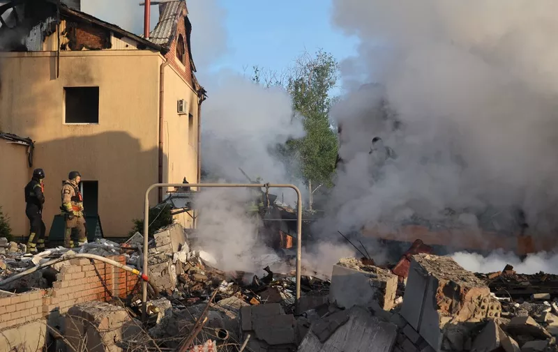 Rescuers are working at a house in Kharkiv, Ukraine, on May 10, 2024, after a Russian missile attack. During the night of May 10, Russian forces attacked Kharkiv with an S-300 missile, injuring an 11-year-old child and a 72-year-old woman in the private sector. Three houses caught fire, with two destroyed and one damaged. In total, 26 buildings were destroyed, and more than 300 windows were shattered. (Photo by Ukrinform/NurPhoto) (Photo by Vyacheslav Madiyevskyy / NurPhoto / NurPhoto via AFP)