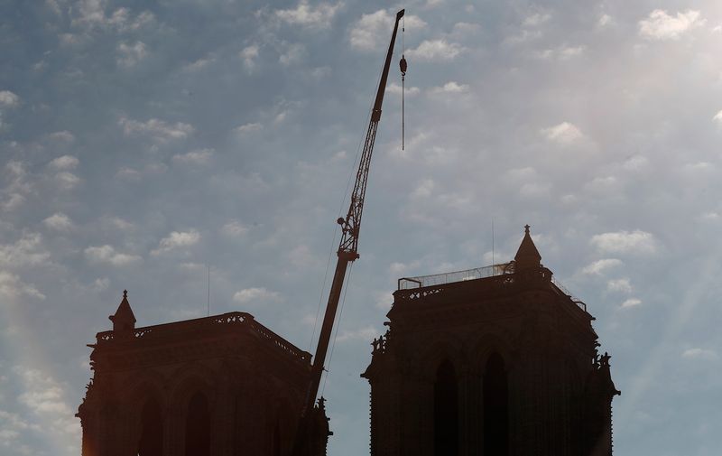 A crane is seen between the belfries of Notre Dame cathedral, in Paris, Friday, April 19, 2019. Rebuilding Notre Dame, the 800-year-old Paris cathedral devastated by fire this week, will cost billions of dollars as architects, historians and artisans work to preserve the medieval landmark. (AP Photo/Thibault Camus)