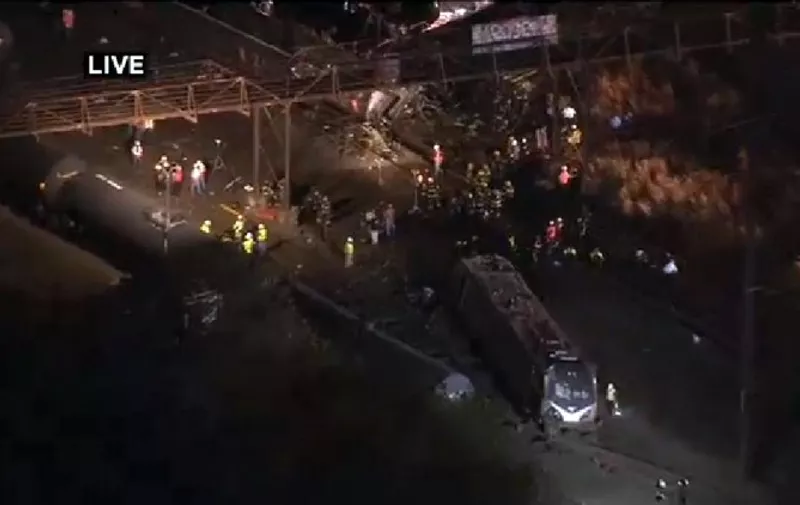 This still image from video courtesy of KYW-TV CBSPhilly shows rescue workers after an Amtrak train derailed late May 12, 2015 near Philadelphia, Pennsylvania with up to 10 cars rolling over, US media reported.   At least five people were killed and dozens injured after a train derailed and overturned in Philadelphia.  Emergency personnel said six of the injured were in critical condition and 53 others were less critically hurt amid chaotic scenes after at least seven train cars, including the engine car, were crushed, turned over on their side or left upside down.   AFP PHOTO / KYW-TV CBSPhilly    == RESTRICTED TO EDITORIAL  USE / MANDATORY CREDIT:  "AFP PHOTO / KYW-TV CBSPhilly"/  NO A LA CARTE SALES  / NO MARKETING / NO ADVERTISING CAMPAIGNS / DISTRIBUTED AS A SERVICE TO CLIENTS ==