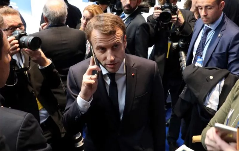 In this photo taken on November 17, 2017 France's President Emmanuel Macron (C) speaks on the phone during the European Social Summit in Gothenburg, Sweden. - French President Emmanuel Macron called an urgent national security meeting on July 22, 2021 to discuss the Israeli-made Pegasus spyware after reports about its use in France emerged this week, a government spokesman said. A consortium of media companies, including the Washington Post, the Guardian and France's Le Monde, reported on Tuesday that one of Macron's phone numbers and those of many cabinet ministers were on a leaked list of potential Pegasus targets. (Photo by ludovic MARIN / AFP)