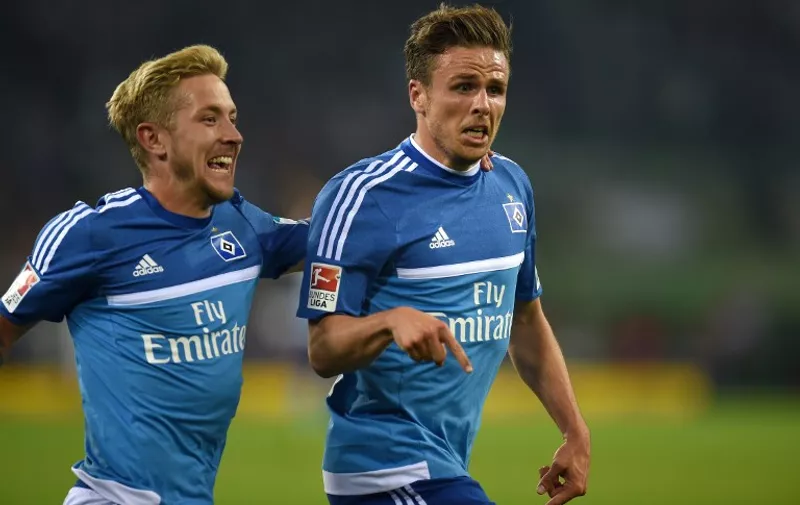 Hamburg's midfielder Nicolai Mueller (R) and Hamburg's midfielder Lewis Holtby react after scoring during the German first division Bundesliga football match Borussia Moenchengladbach vs Hamburger SV in Moenchengladbach, western Germany, on September 11, 2015.  

RESTRICTIONS: DURING MATCH TIME: DFL RULES TO LIMIT THE ONLINE USAGE TO 15 PICTURES PER MATCH AND FORBID IMAGE SEQUENCES TO SIMULATE VIDEO. 
== RESTRICTED TO EDITORIAL USE ==
FOR FURTHER QUERIES PLEASE CONTACT DFL DIRECTLY AT + 49 69 650050.