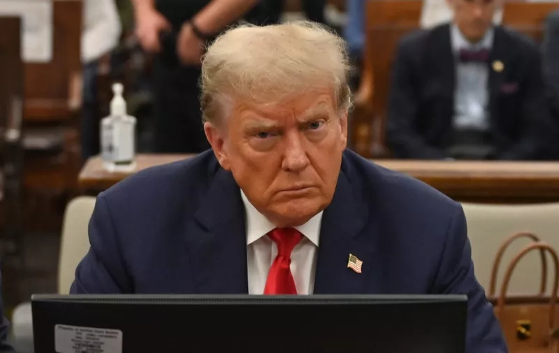 (FILES) Former US President Donald Trump sits inside the courtroom for the third day of his civil fraud trial in New York on October 4, 2023. A US judge ordered Trump on February 16, 2024 to pay nearly $355 million after finding him liable for fraud and banned him from running businesses in New York state for three years. (Photo by ANGELA WEISS / AFP)