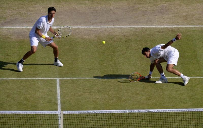 Croatia's Ivan Dodig (R) and Brazil's Marcelo Melo play against US players Bob and Mike Bryan in the men's doubles final match on day twelve of the 2013 Wimbledon Championships tennis tournament at the All England Club in Wimbledon, southwest London, on July 6, 2013. AFP PHOTO / ADRIAN DENNIS -- RESTRICTED TO EDITORIAL USE