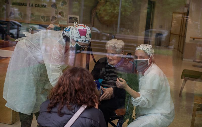 BARCELONA, SPAIN - MAY 14: Felisa Gonzalez looks at her mother, Maria Maillo, through the window during a visit to a nursing home on May 14, 2020 in Barcelona, Spain. While Some parts of Spain have entered the so-called "Phase One" transition from its coronavirus lockdown, allowing many shops to reopen as well as restaurants who serve customers outdoors, nursing homes are still not allowing visits of relatives. Locations that were harder hit by coronavirus (Covid-19), such as Madrid and Barcelona, remain in a stricter "Phase 0" quarantine. (Photo by David Ramos/Getty Images)