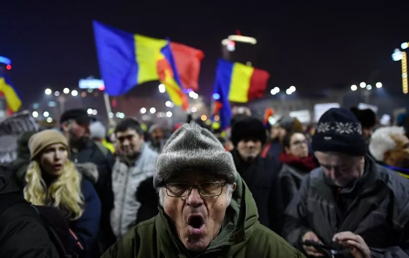 People take part in a protest in front of the government headquarters in Bucharest against the controversial decree to pardon corrupt politicians and decriminalize other offenses on February 2, 2017. 
Around 60,000 people rallyed in Bucharest for a third day in a row after a controversial law giving pardon to corruption crimes was adopted by emergency order late evening on Januarz 31, 2017.  / AFP PHOTO / DANIEL MIHAILESCU