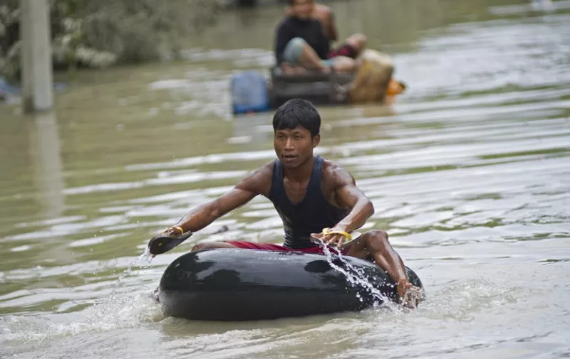 Flood-affected residents use make-shift rafts to travel through floodwaters in Kalay, upper Myanmar's Sagaing region on August 3, 2015. Relentless monsoon rains have triggered flash floods and landslides, destroying thousands of houses, farmland, bridges and roads -- with fast-flowing waters hampering relief efforts.  AFP PHOTO / Ye Aung THU