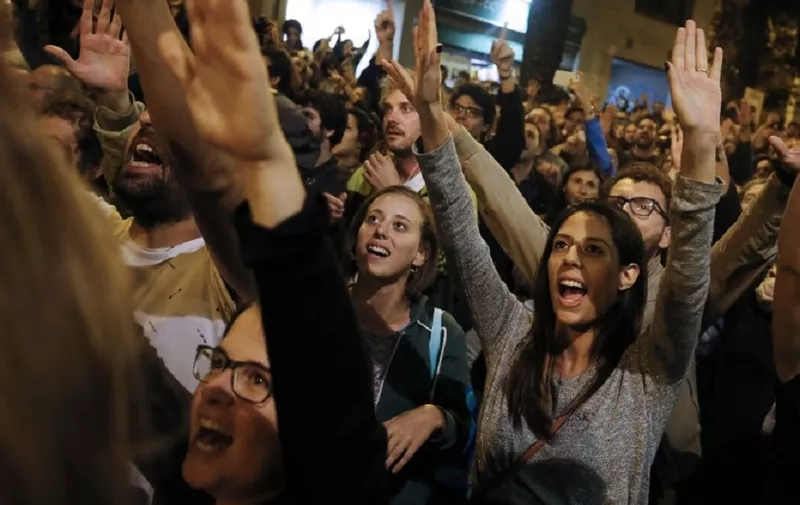 People celebrate after the closing of the 'Espai Jove La Fontana' (La Fontana youth center) polling station, on October 1, 2017 in Barcelona.

Spanish riot police stormed voting stations today as they moved to stop Catalonia's independence referendum after it was banned by the central government in Madrid. At least 92 people were confirmed injured as hundreds tried to prevent the polling stations from being closed, Catalan officials said. A total of 465 people were treated at hospitals and health centres, while Spain's interior ministry said 12 police officers were injured.
 / AFP PHOTO / PAU BARRENA