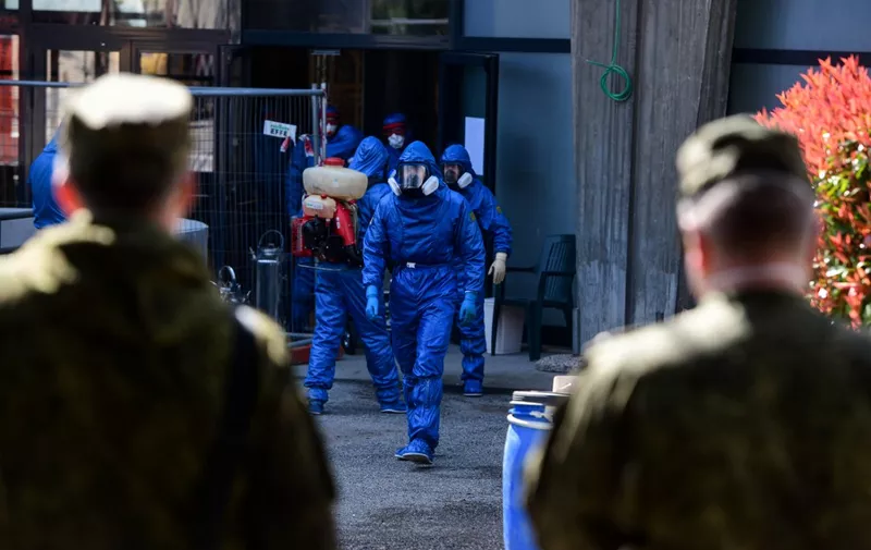 A Russian Army specialist walks outside the Honegger nursing home where 35 people have died so far from coronavirus in Albino, Italy, on March 28, 2020, amid the spread of the COVID-19 (new coronavirus) pandemic. - Italy recorded a shocking spike in coronavirus deaths on March 27 with 969 new victims, the worst daily record for any country since the pandemic began. The infection rate however continued its downward trend, with the civil protection agency reporting nearly 86,500 confirmed cases in Italy. (Photo by Piero CRUCIATTI / AFP)