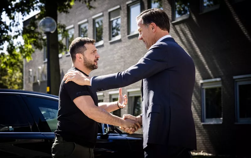 Ukrainian President Volodymyr Zelensky (L) and outgoing Dutch Prime Minister Mark Rutte shake hands during a visit to the Eindhoven Military Air Base, in Eindhoven, on August 20, 2023. (Photo by ROB ENGELAAR / ANP / AFP) / Netherlands OUT