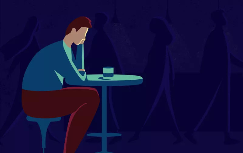 This illustration shows a sad man sitting at a table, he is in depression, the world around him has lost all color and seems faceless