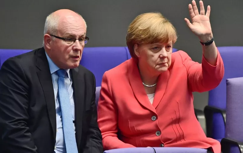 German Chancellor Angela Merkel (R) gestures as she confer with her parliamentary group leader of the Christian Democrats Volker Kauder during a debate in the  Bundestag, the German lower house of parliament in Berlin on July 17, 2015. German lawmakers will vote during todays sitting in the Bundestag on entering into negotiations on the new aid package for Greece. AFP PHOTO / JOHN MACDOUGALL