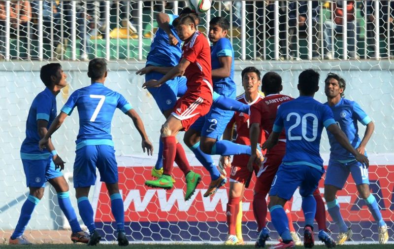 Indian and Nepalese football players vie for the ball during a qualifier match for the FIFA World Cup Russia 2018 at Dasrath Stadium in Kathmandu on March 17, 2015. The teams drew 0-0. AFP PHOTO / PRAKASH MATHEMA