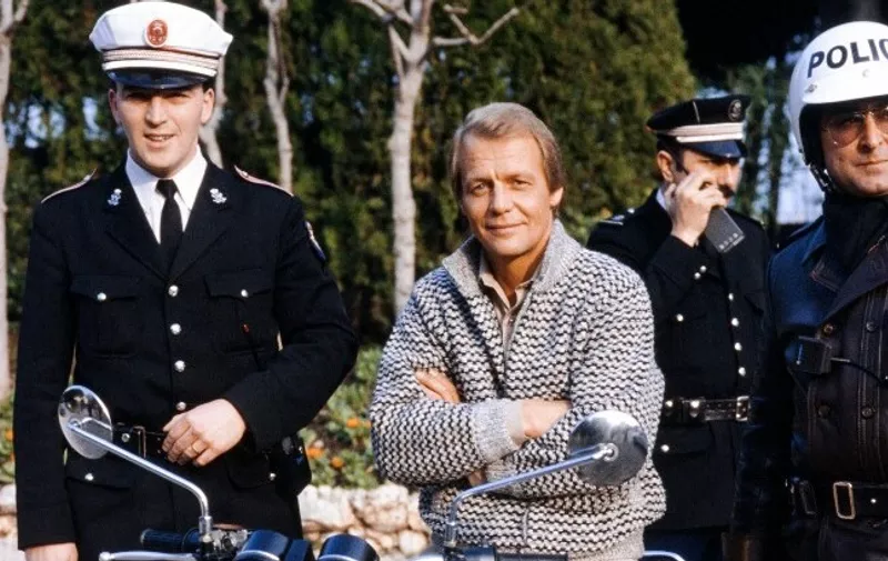 American actor David Soul, worldwide famous as detective Hutch poses with Monaco's policemen at Monte Carlo on February 15, 1985 during the TV-Video festival. The British, since 2004, David Soul died on January 5, 2024 at London, announced his wife Helen Snell. (Photo by Raph GATTI / AFP)