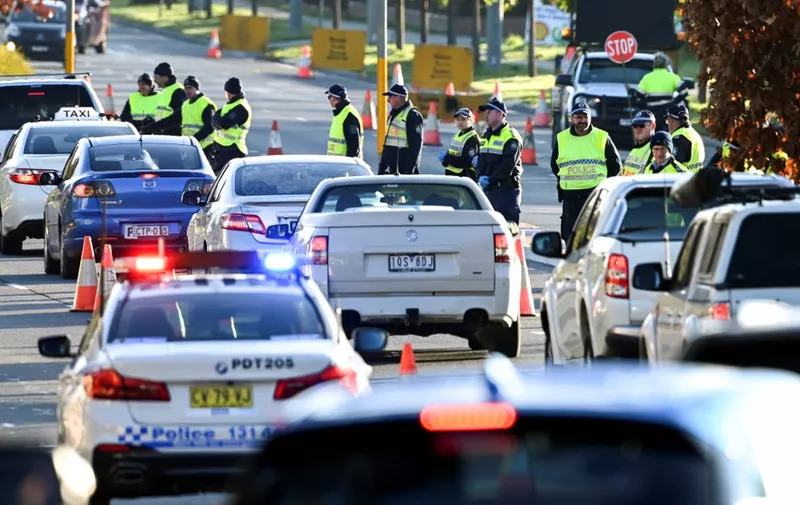 Police in the southern New South Wales (NSW) border city of Albury check cars crossing the state border from Victoria on July 8, 2020 after authorities closed the border due to an outbreak of COVID-19 coronavirus in Victoria. - With the city of Melbourne going into lockdown for the next six weeks, the entire state of Victoria will effectively be sealed off from the rest of the country with the state border to NSW closing on 08 July. (Photo by William WEST / AFP)