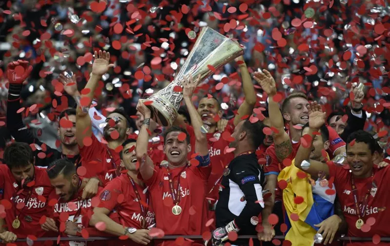 Sevilla players celebrate with trophy after the UEFA Europa League final football match between FC Dnipro Dnipropetrovsk and Sevilla FC at the Narodowy stadium in Warsaw, Poland on May 27, 2015. Sevilla FC won 2-3.    AFP PHOTO / JANEK SKARZYNSKI