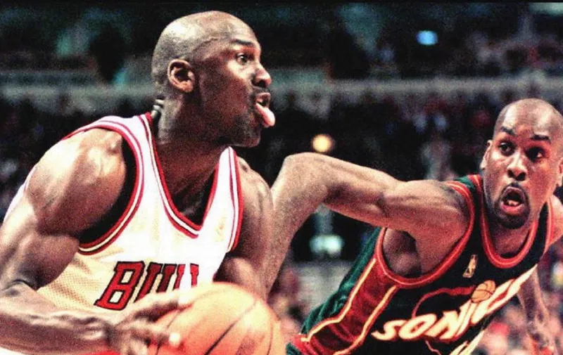 Michael Jordan of the Chicago Bulls (L) looks to make a basket as Seattle SuperSonics guard Gary Payton (R) defends in the fourth quarter of the 18 March game at the United Center in Chicago, Illinois. The Bulls defeated the Supersonics 89-87 in overtime. AFP Photo by Vincent LAFORET (Photo by VINCENT LAFORET / AFP)