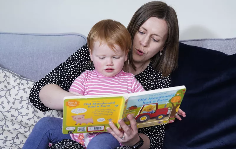Opal Sandy, who was born completely deaf because of a rare genetic condition, and can now hear unaided for the first time after receiving ground-breaking gene therapy at 11-months-old, reads with her mother Jo at their home in Eynsham, Oxfordshire. Picture date: Tuesday May 7, 2024.,Image: 871349243, License: Rights-managed, Restrictions: , Model Release: no