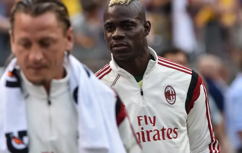 AC Milan's Mario Balotelli (R) and Philippe Mexes walk on the pitch before a Champions Cup match against Manchester City at Heinz Field in Pittsburgh on July 27, 2014. Manchester City won 5-1.   AFP PHOTO/Nicholas KAMM
