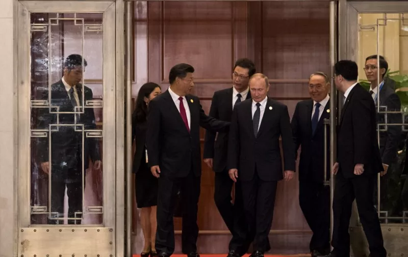 China's President Xi Jinping (C left) gestures to Russia's President Vladimir Putin (C right) as they walk across a garden prior to a dinner banquet at the G20 Summit in Hangzhou on September 4, 2016.
G20 leaders confront a sluggish global economy and the winds of populism as they open annual talks, but the long war in Syria and the South China Sea territorial dispute hang over the summit. / AFP PHOTO / JOHANNES EISELE