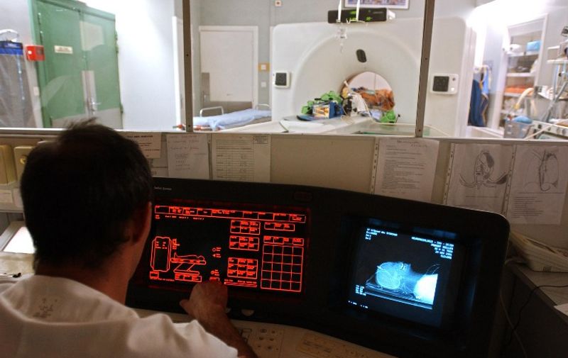Un manipulateur du service de radiologie de l'hôpital général de Dijon, procède le 20 novembre 2001, au scanner de la tête d'un patient tombé dans le coma à la suite d'un accident.  / AFP PHOTO / ERIC FEFERBERG