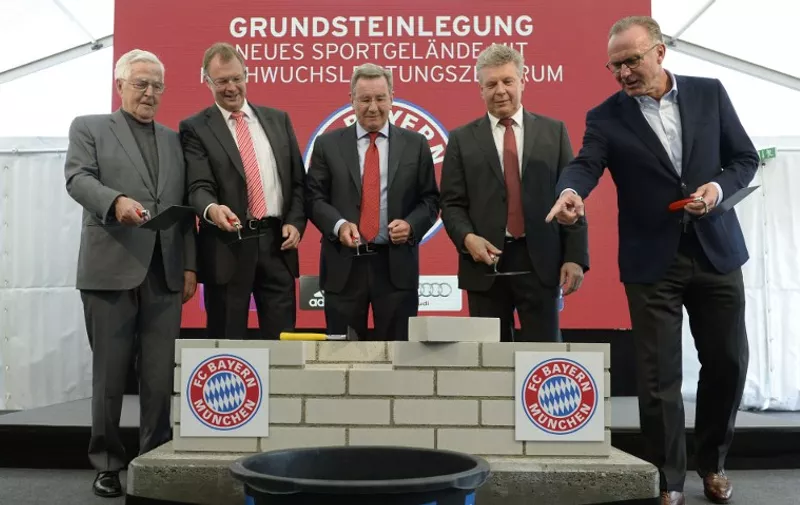 (L-R) Architect Albert Speer, mayor of Oberschleissheim Christian Kuchlbauer, President of German Bundesliga football club FC Bayern Munich Karl Hopfner, mayor of Munich Dieter Reiter and CEO of FC Bayern Munich Karl-Heinz Rummenigge prepare the laying of the foundation stone for the new sports youth activity center of Bayern Munich in Munich, southern Germany, on October 16, 2015. AFP PHOTO / CHRISTOF STACHE