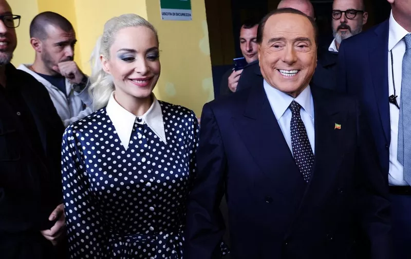 This photo obtained from Italian news agency Ansa shows former Italian Prime Minister and leader of the Italian right-wing party "Forza Italia" (FI), Silvio Berlusconi, and his partner Marta Fascina arrive to cast their vote on September 25, 2022 at a polling station in Milan, as as the country is voting for the legislative election. Italians on September 25 were voting in a pivotal legislative election, with the far right expected to lead the eurozone's third-largest economy for the first time since World War II. (Photo by MATTEO BAZZI / ANSA / AFP) / Italy OUT