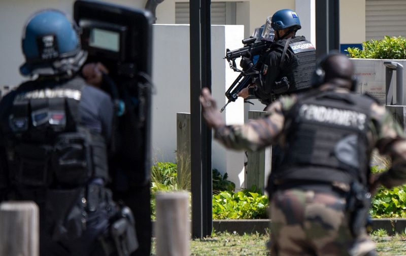 Members of the National Gendarmerie Intervention Group (GIGN) run  near the site where a suspect has been seen after a municipal policewoman was attacked with a knife on May 28, 2021, in La Chapelle-sur-Erdre, near Nantes, western France. - A suspect ran away after a knife attack on a policewoman in La Chapelle-sur-Erdre, near Nantes, on May 28, 2021. (Photo by LOIC VENANCE / AFP)