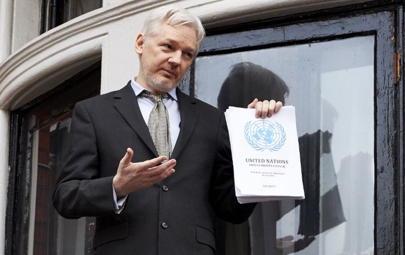 WikiLeaks founder Julian Assange addresses the media holding a printed report of the judgement of the UN's Working Group on Arbitrary Detention on his case from the balcony of the Ecuadorian embassy in central London on February 5, 2016.
During a press conference on February 5 Julian Assange, speaking via video-link, called for Britain and Sweden to "implement" a UN panel finding saying that he should be able to walk free from Ecuador's embassy, where he has lived in self-imposed confinement since 2012. / AFP / NIKLAS HALLE'N