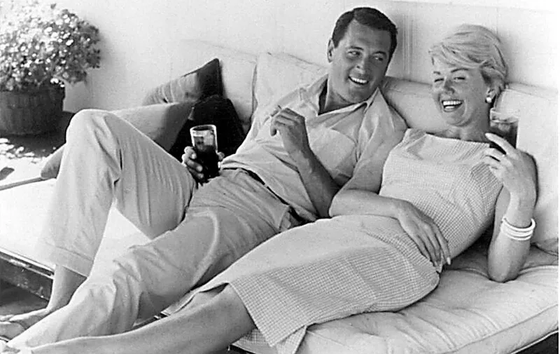 This undated file photo shows US actress Doris Day (R) relaxing with US actor Rock Hudson (L). Day and Hudson starred in several romance/comedy Hollywood films in the 1960's. Day was born in 1924 in Cincinnati, Ohio and was a band singer before she became a film star and recording artist. Hudson died twenty years ago, 02 October 1985, at the age of 59 due to complications from AIDS. (Photo by HO / HO / AFP)