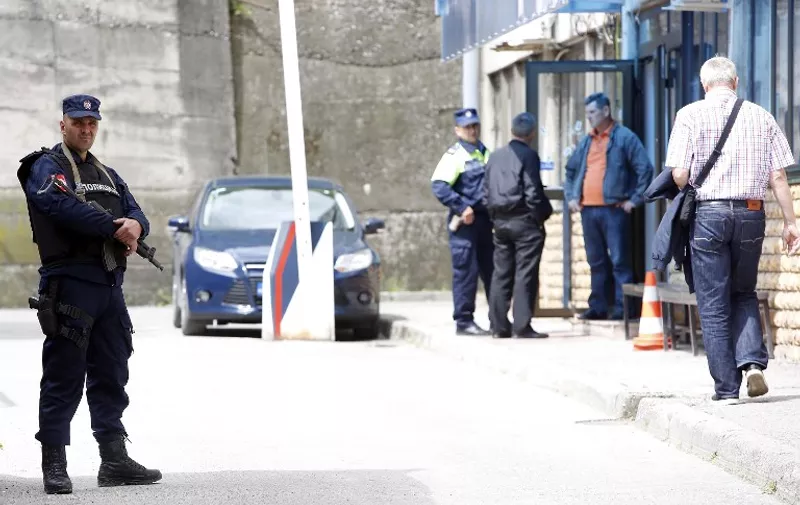 Bosnian policemen secure a perimeter around a crime scene at the police station in eastern Bosnia town of Zvornik, on April 28, 2015. Late, on April 27, a  24-year-old gunman shouting "Allahu Akbar" (God is greatest) opened fire on the police station, killing one officer and wounding two others before being killed in a shootout. Two more policemen were hospitalised. AFP PHOTO / STR
