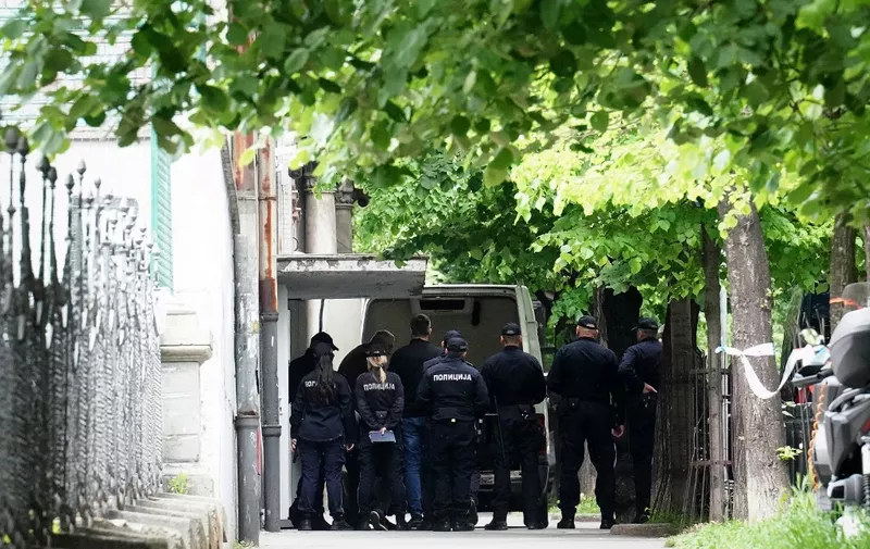 Police officers guard the school entrance as the bodies of the victims are loaded into a van following a shooting at a school in the capital Belgrade on May 3, 2023. - The teenage suspect accused of killing nine people on Wednesday "planned the shooting for a month and made a list of kids he planned to kill," Veselin Milic, Belgrade's police chief, told a press conference. (Photo by Oliver Bunic / AFP)