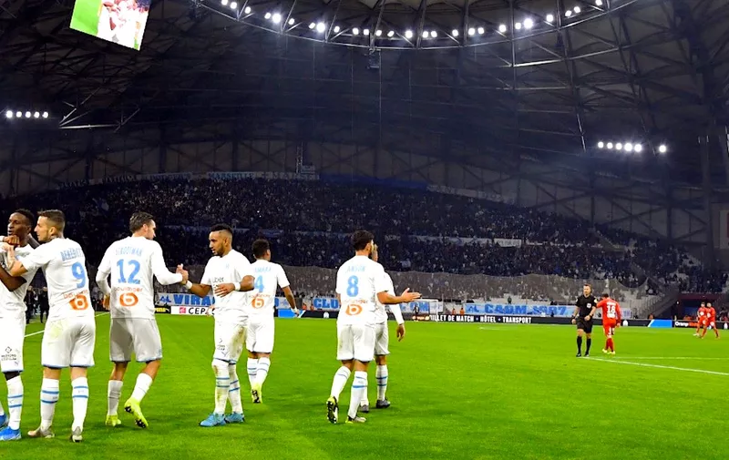 Marseille's Guinean midfielder Bouna Sarr (L) is congratulated by his teammates during the French L1 football match between Olympique de Marseille (OM) and Brest at the Orange Velodrome stadium in Marseille, southeastern France, on November 29, 2019. (Photo by GERARD JULIEN / AFP)