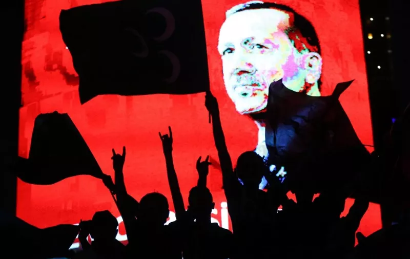Supporters stands in front of a screen displaying a portrait of Turkish President Recep Tayyip Erdogan during a rally at Kizilay Square in Ankara on July 20, 2016, 

Erdogan on Wednesday declared a three-month state of emergency, vowing to hunt down the "terrorist" group behind last week's bloody coup attempt. / AFP PHOTO / ADEM ALTAN