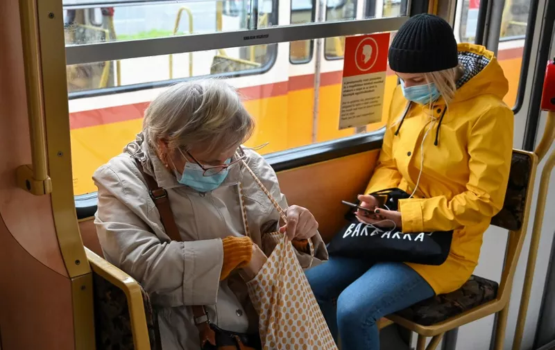 Commuters wear face masks as they travel by tram in Budapest on November 10, 2020, hours before as a partial lockdown comes into force. - Hungarian Prime Minister Orban announced a partial lockdown aimed at curbing a surge in coronavirus deaths. The measures, due to start November 11, 2020, include an extension of an existing night-time curfew, a ban on gatherings, and closures of bars, restaurants and cultural venues, Orban said in a Facebook video. Sporting events must be played behind closed doors, while secondary schools and universities must move online, although kindergartens and primary schools can remain open. (Photo by ATTILA KISBENEDEK / AFP)