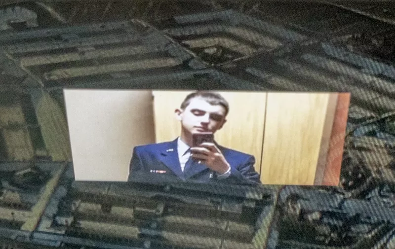 This photo illustration created on April 13, 2023, shows the suspect, national guardsman Jack Teixeira, reflected in an image of the Pentagon in Washington, DC. - FBI agents on Thursday arrested a young national guardsman suspected of being behind a major leak of sensitive US government secrets -- including about the Ukraine war. US Attorney General Merrick Garland announced the arrest made "in connection with an investigation into alleged unauthorized removal, retention and transmission of classified national defense information." (Photo by Stefani REYNOLDS / AFP)
