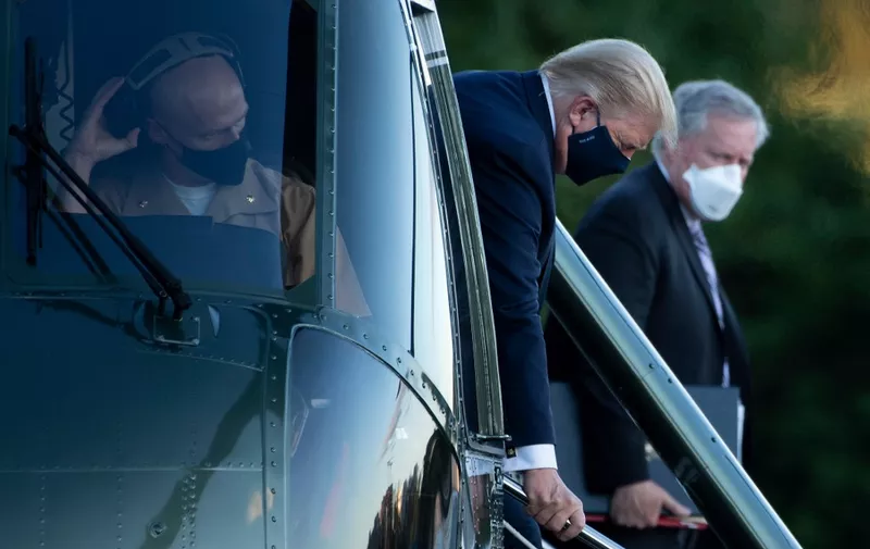 White House Chief of Staff Mark Meadows (R) watches as US President Donald Trump walks off Marine One while arriving at Walter Reed Medical Center in Bethesda, Maryland on October 2, 2020. - President Donald Trump will spend the coming days in a military hospital just outside Washington to undergo treatment for the coronavirus, but will continue to work, the White House said Friday (Photo by Brendan Smialowski / AFP)