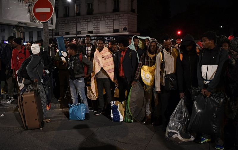 Migrants gather and wait before being evacuated from a makeshift migrant camp set up between the metro stations of Jaures and Stalingrad, in Paris, on September 16, 2016. (Photo by CHRISTOPHE ARCHAMBAULT / AFP)