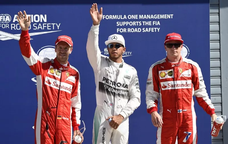 (LtoR) Third placed Ferrari's German driver Sebastian Vettel, pole position winner Mercedes AMG Petronas F1 Team's British driver Lewis Hamilton and second placed Ferrari's Finnish driver  Kimi Raikkonen celebrate after the qualifying session at the Autodromo Nazionale circuit in Monza on September 5, 2015 ahead of the Italian Formula One Grand Prix.  AFP PHOTO / OLIVIER MORIN