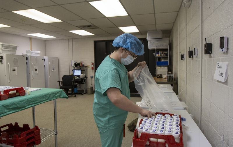 Lab tech, Daniel Smith prepares three ounce servings of breast milk ready to be shipped out to nearby hospitals from the Mountain West Mothers Milk Bank on December 12, 2019 in Salt Lake City. - For a baby in the Neonatal Intensive Care Unit (NICU), there is nothing as nourishing as breast milk, which contains vitamins, minerals, fatty acids, immune factors, complex oligosaccharides (complex sugar molecules), antibodies and stem cells; it is effectively medicine. (Photo by Natalie BEHRING / AFP)