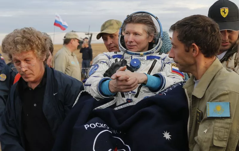 Expedition 44 crew member Gennady Padalka (C) of Roscosmos is carried to the medical tent shortly after he and visiting crew members Andreas Mogensen of ESA (European Space Agency) and Aidyn Aimbetov of the Kazakh Space Agency landed in a remote area outside the town of Zhezkazgan in Kazakhstan on 12 September 2015. A three-person crew from the International Space Station landed safely in the steppes of Kazakhstan. AFP PHOTO / POOL / YURI KOCHETKOV